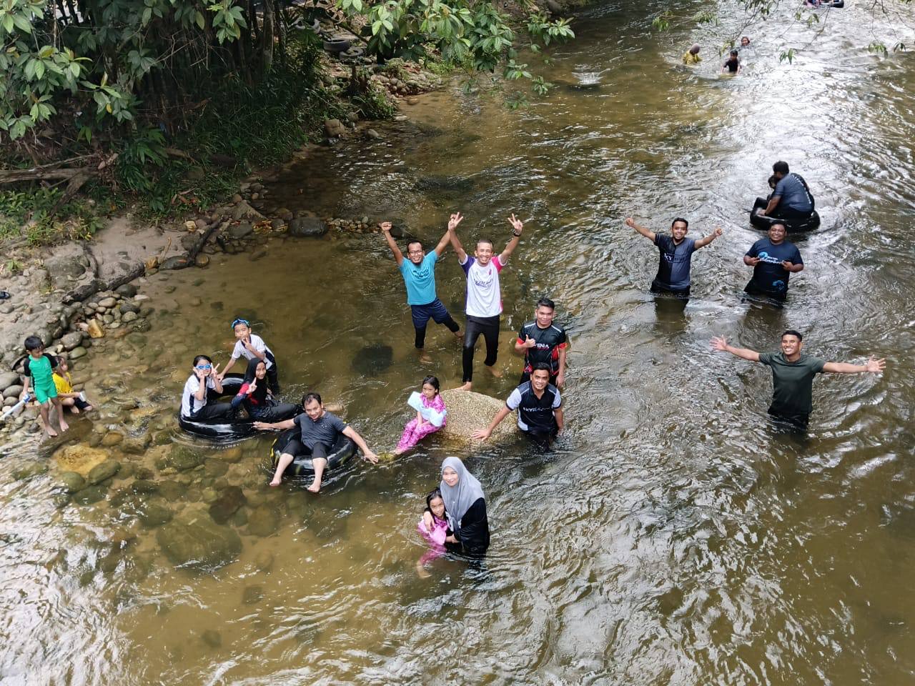 Participants standing and sitting in the river at Sedim Riverside.
